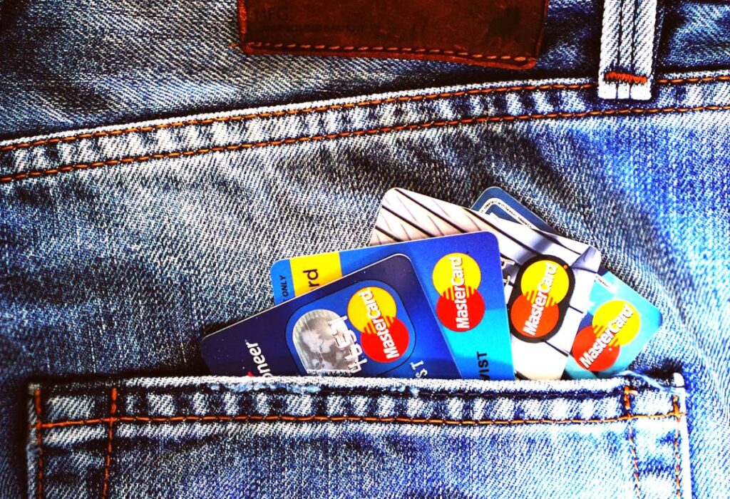Foto meramente ilustrativa de close de vários cartões de crédito em leque em um bolso de calça jeans. Ela remete às cooperativas de crédito, tema do Prêmio Sicredi Comunicação em Rede 2026.
